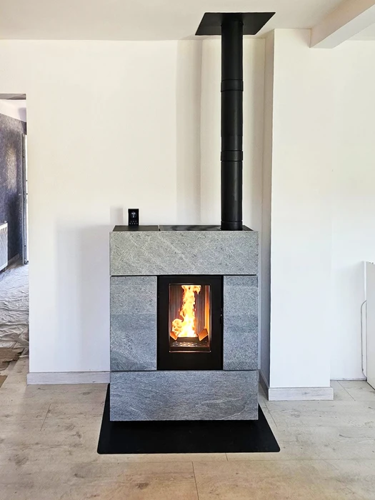 Salon moderne avec cheminée à foyer fermé intégrée dans mur beige, niches de rangement bûches de chaque côté