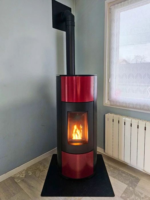 Intérieur chaleureux avec poêle à bois en fonctionnement, flammes visibles à travers la vitre, réserve de bûches intégrée dans la partie basse