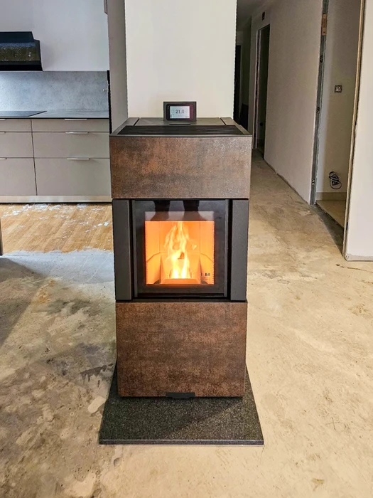 Salon moderne avec cheminée à foyer fermé intégrée dans mur beige, niches de rangement bûches de chaque côté