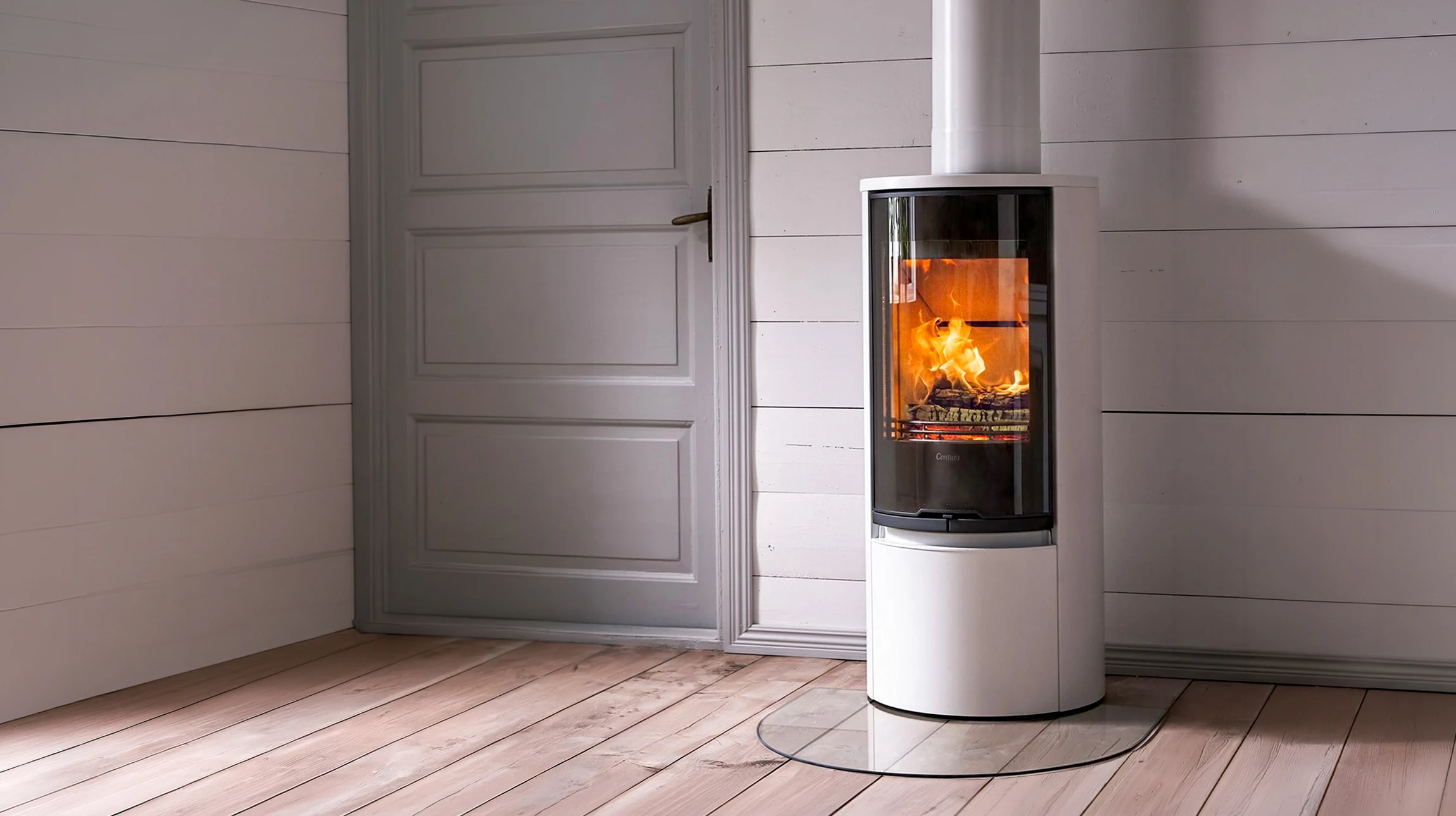 Intérieur moderne avec poêle à bois en fonte noire en fonctionnement, flammes visibles dans le foyer vitré
