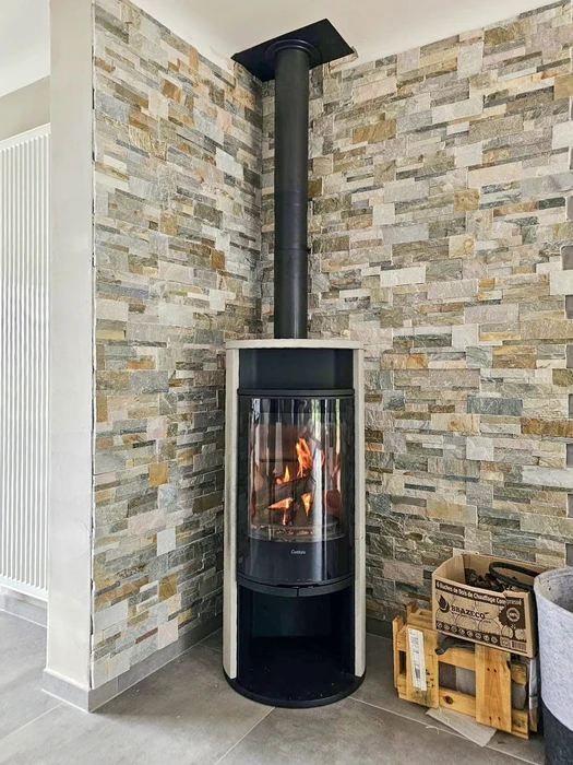 Intérieur moderne avec cheminée à bois encastrée en fonctionnement, flammes visibles dans le foyer ouvert
