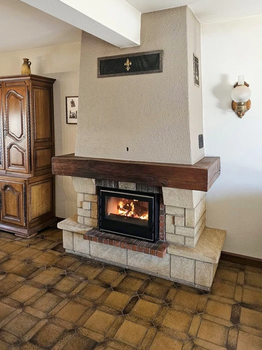 Intérieur moderne avec cheminée d'angle suspendue en fonctionnement, flammes visibles