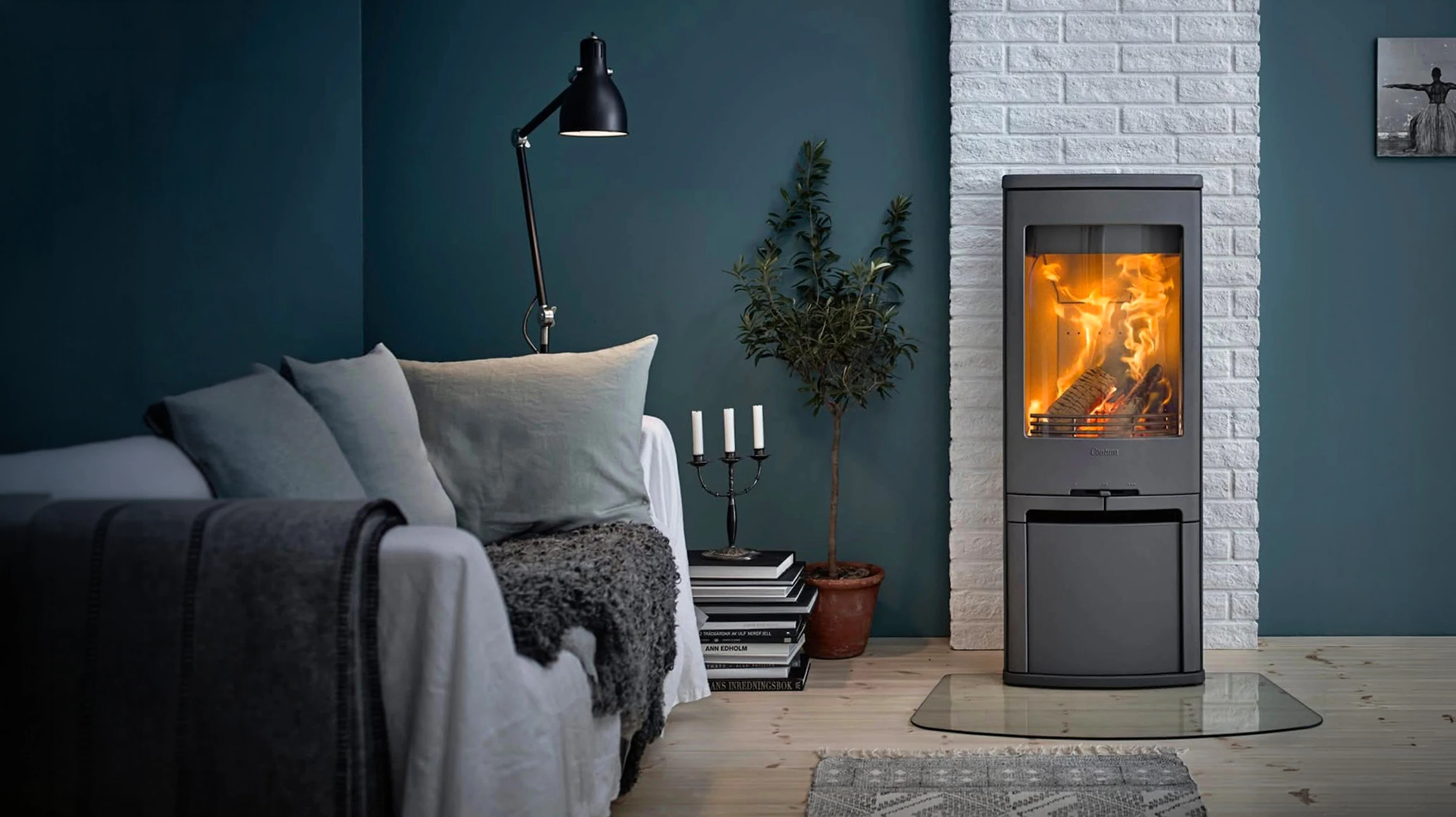 Ramoneur professionnel en vêtements de travail et équipement de sécurité (gilet haute visibilité, casque ou chapeau) effectuant un ramonage de conduit de cheminée sur la façade extérieure d'une maison. Le ramoneur est visible en haut de la maison avec ses outils professionnels de ramonage, illustrant clairement l'intervention d'entretien et de sécurité du conduit. La scène montre un vrai cadre résidentiel avec ciel dégagé, mettant en évidence le professionnalisme et la sécurité du service de ramonage certifié.